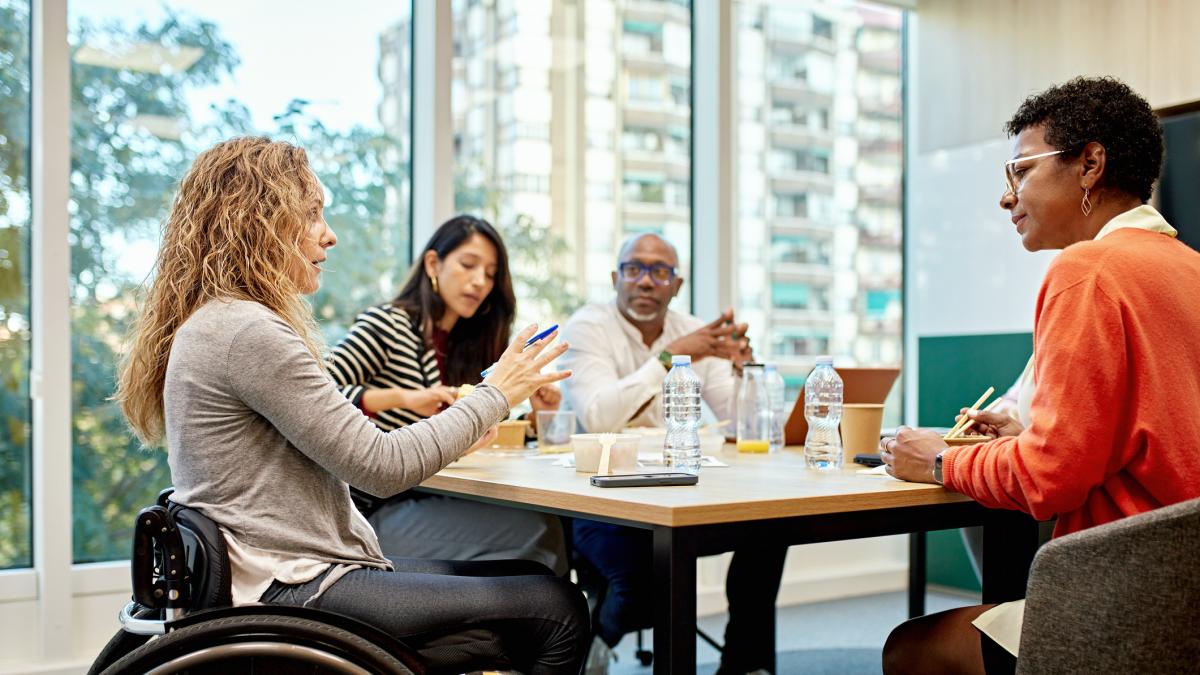 Ethnically, racially, and gender diiverse people meeting; one person in a wheelchair.